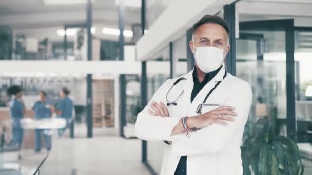 Mature man, doctor and pride for mask in hospital, healthcare and care in clinic or service. Male person, medical professional and safety with insurance, nurse and confidence for career in portrait. - Footage, Video