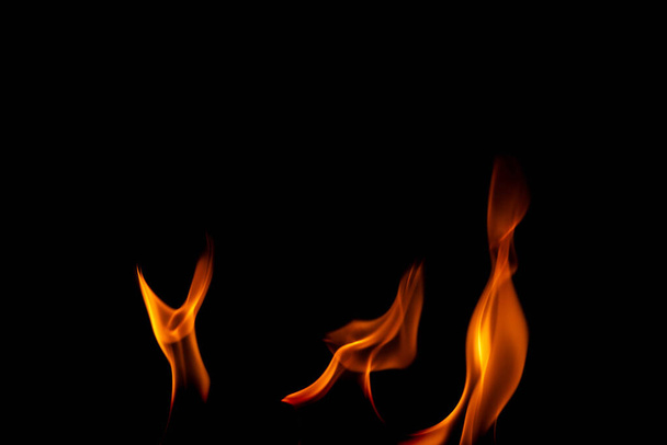 Llamas calientes sobre un fondo negro. Hermosa llama de fuego en la oscuridad. Resumen de llamas ardientes y humo. - Foto, imagen