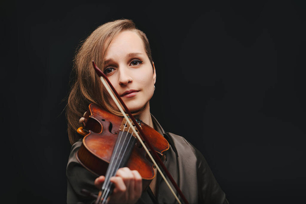 Die Verbindung der Künstlerin mit ihrer Geige scheint durch und zeigt die innige Verbindung zwischen Musiker und Instrument - Foto, Bild