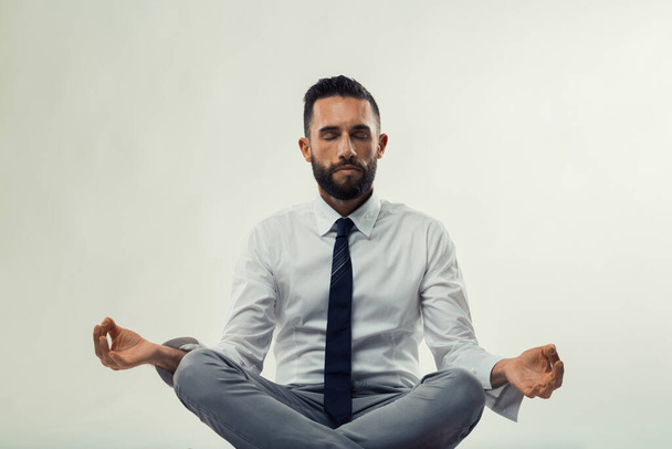 Geschäftsmann meditiert in friedlicher Pose, strahlt Ruhe und Konzentration aus - Foto, Bild
