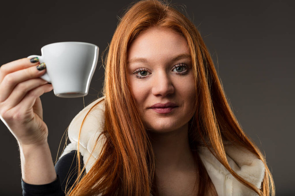 tibio encanto de una pelirroja sosteniendo su café, ojos relucientes con historias - Foto, Imagen