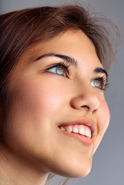 Close-up van een vrouw met hoopvolle ogen, het vastleggen van de essentie van optimistische anticipatie - Foto, afbeelding