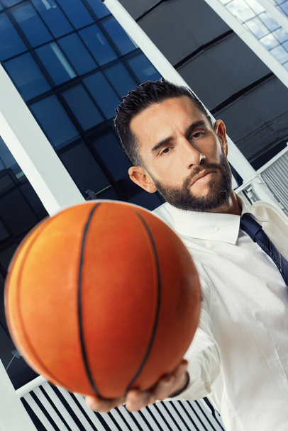 Profissional confiante usa basquete para representar a importância da precisão e do trabalho em equipe no negócio - Foto, Imagem