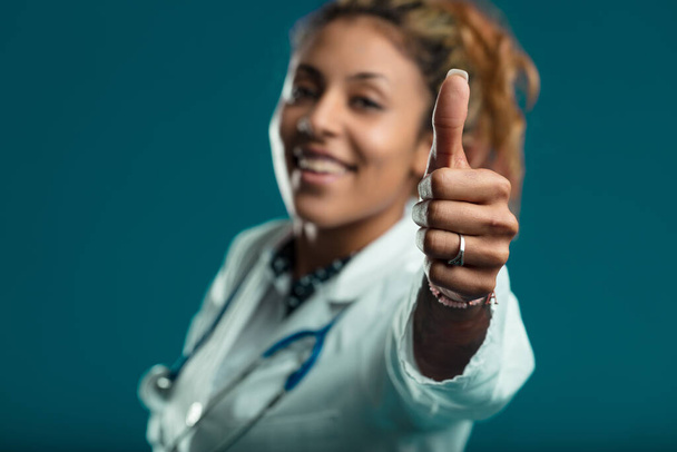 gest podnoszenia kciuków u lekarza emanuje optymizmem i sukcesem w swojej dziedzinie - Zdjęcie, obraz