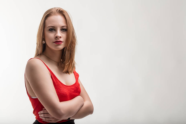 Rote Kleidung ergänzt die selbstbewusste und doch gelassene Haltung der jungen Frau - Foto, Bild