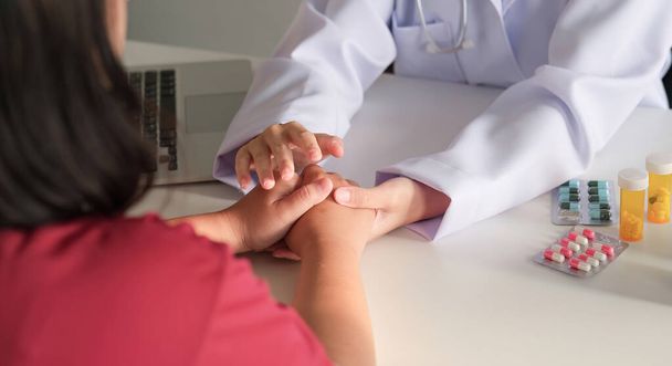 Ärzte halten Händchen und beraten Patienten. Mut machen bei der Behandlung von Krankheiten. - Foto, Bild