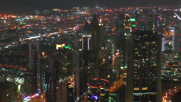 Wolkenkrabbers en drukke straten van Dubai genomen van Burj Khalifa. Luchtfoto van de avond moderne stad. Avondverlichting. - Video