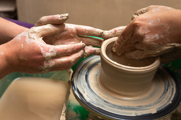 Argilla, ceramica o mani in un laboratorio di design che lavora su una tazza o tazza artistica. La mano di un artista creativo o di un operaio che fa artigianato in scultura - Foto, immagini