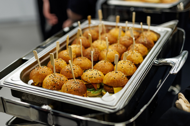 Mini hambúrgueres com sementes de gergelim em uma bandeja de metal. - Foto, Imagem