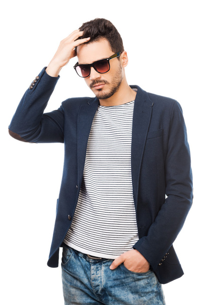 Man wearing sunglasses holding hand in hair - Foto, immagini