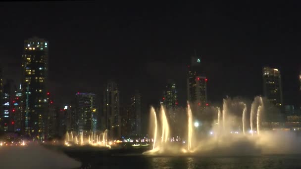 Dubai Çeşmesi Su Şelalesi 'nin gece vakti dans eden çeşmesinin manzarası. Dubai alışveriş merkezinde lazer ışığı, Burj Halife binası yakınlarında.. - Video, Çekim