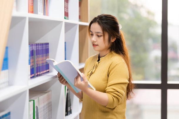 πορτρέτο της Ασιάτισσας φοιτήτριας που σπουδάζει στη βιβλιοθήκη - Φωτογραφία, εικόνα