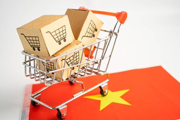 Box with shopping online cart logo and Vietnam flag, Import Export Shopping online or commerce financiary product store produce, trade, producer concept. - Фото, зображення