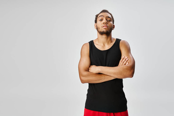 atraente desportivo afro-americano homem posando com braços cruzados no peito e olhando para a câmera - Foto, Imagem