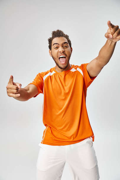 joyeux sportif homme afro-américain gesticulant et pointant activement, concept de pari en ligne - Photo, image
