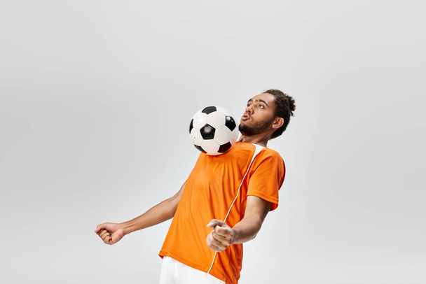 apuesto atlético afroamericano deportista en uniforme vibrante cómodo jugando fútbol activamente - Foto, imagen