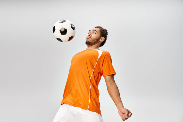 bell'aspetto atletico giovane uomo africano americano in vibrante sportwear giocare a calcio attivamente - Foto, immagini