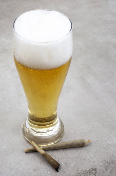 Giunto alla marijuana con bicchiere di birra sulla superficie grigia del grunge - Foto, immagini