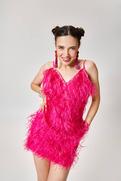 Mesés barna nő divatos rózsaszín ruha és divatos ékszerek nevetve vidáman elszigetelt szürke - Fotó, kép