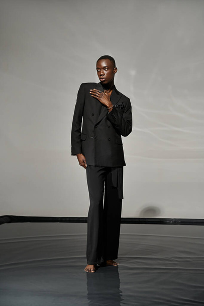 Houkutteleva tyylikäs afrikkalainen amerikkalainen mies seksikäs unbuttoned puku poseeraa harmaa vetinen tausta - Valokuva, kuva