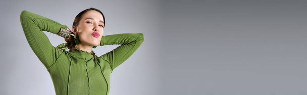 Portrét nóbl brunetky ženy v celkové zelené trendy vzhled foukání polibky na fotoaparát, banner - Fotografie, Obrázek