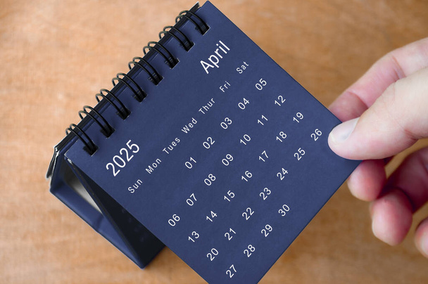 April 2025 black and white calendar on wooden desk. Calendar and new month concept. - Photo, Image