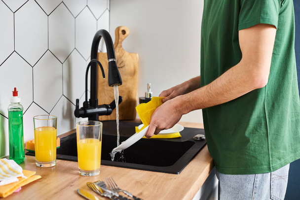 oříznutý pohled na člověka v běžné domácí prádlo prací talíř s čističem v dřezu, zatímco v kuchyni doma - Fotografie, Obrázek
