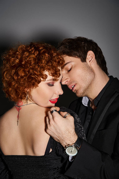houkutteleva seksikäs pari musta tyylikäs puvut suudella ja halata rakastavasti harmaalla taustalla - Valokuva, kuva