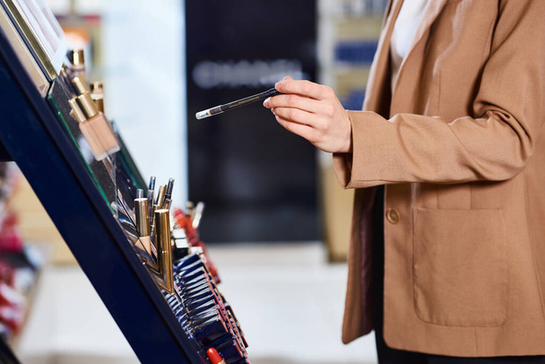 kivágott kilátás kaukázusi nő üzleti alkalmi szedés új rúzs, míg a kozmetikai boltban - Fotó, kép