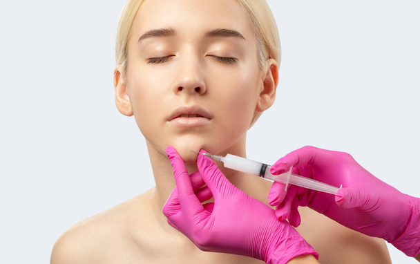 Kosmetolog provádí lipolytické injekce, aby spálil tuk na bradě, tvářích a krku ženy proti dvojité bradě. Dámská estetická kosmetika v salonu krásy.Koncept kosmetologie. - Fotografie, Obrázek