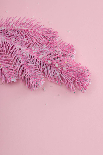 Composición tradicional de Año Nuevo en tonos de color rosa. Decoración festiva, rama rosada del árbol de Navidad, copos de nieve. Fondo pastel, plano laico, vista superior - Foto, Imagen