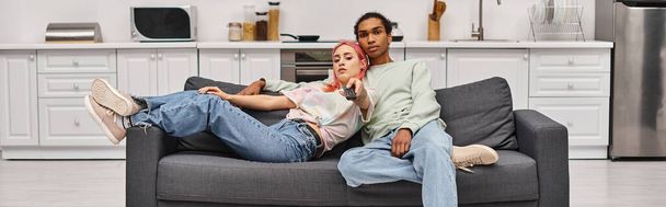 aansprekende interraciale paar in homewear tijd doorbrengen samen en films kijken thuis, banner - Foto, afbeelding