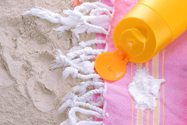 Verschütteter kosmetischer Sonnenschutz für Kleidung am Strand. Weißes Pflegeprodukt. Der Alltag schmutziger Fleck Konzept. Ansicht von oben. Hochwertiges Foto - Foto, Bild