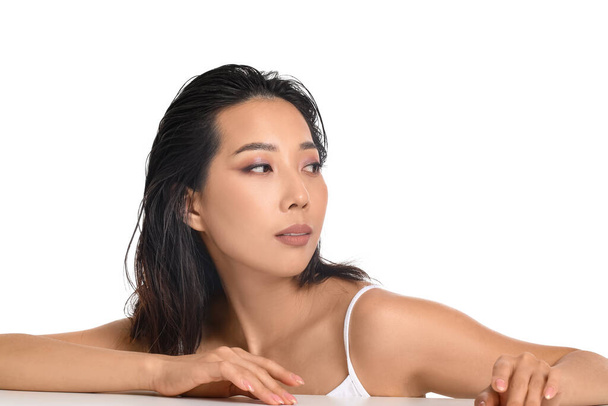 Kaunis nuori aasialainen nainen, jolla on terve iho valkoisella taustalla
 - Valokuva, kuva