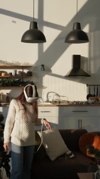 Una ragazza brillante in un appartamento soleggiato con un auricolare di realtà virtuale. Filmati 4k di alta qualità - Filmati, video