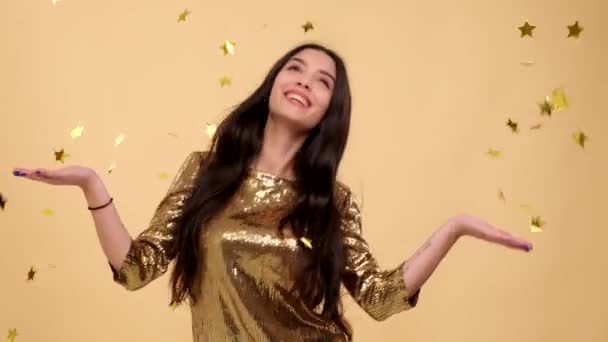 Lighthearted Caucasian woman dances with joy against a warm beige background, creating a scene that radiates happiness and captures the liberating spirit of carefree movement in a delightful setting. - Footage, Video