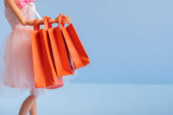 Giorno di San Valentino vendita concetto di shopping. Dall con borse della spesa rosse su sfondo blu pastello - Foto, immagini
