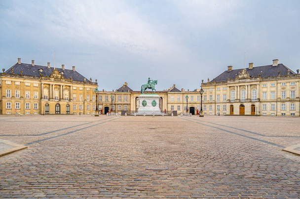 COPENHAGEN, DANIA - LIPIEC 8, 2014: Pałac Amalienborg, oficjalna rezydencja duńskiej rodziny królewskiej w Kopenhadze, Dania. Składa się z czterech identycznych pałaców Rococo wokół ośmiobocznego dziedzińca; w centrum placu znajduje się monumentalny ekwiwalent - Zdjęcie, obraz