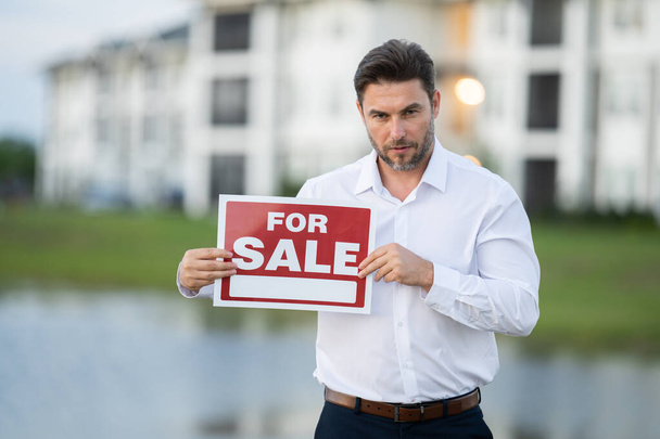 Businessman buying and selling houses and real estate. real state agent giving new house key. Estate agent with customer before contract signature. male real state agent with a for sale or rent sign. - Photo, Image