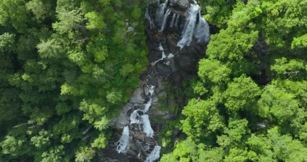 Вид с воздуха на водопад Уайтуотер в Национальном лесу Нантахала, Северная Каролина, США. Чистая вода падает с каменистых валунов между зелеными пышными лесами. - Кадры, видео