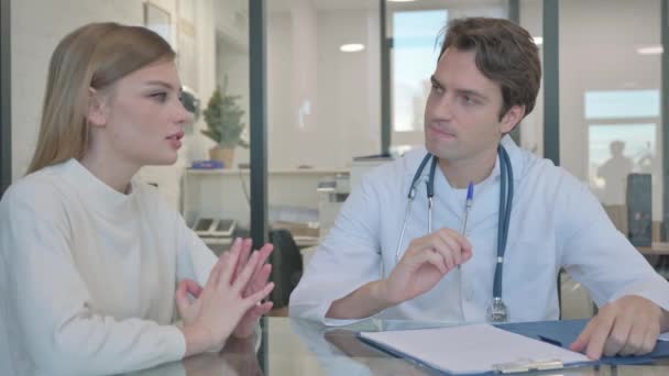 Médico discutiendo plan de tratamiento con mujer joven, escribiendo medicina - Metraje, vídeo