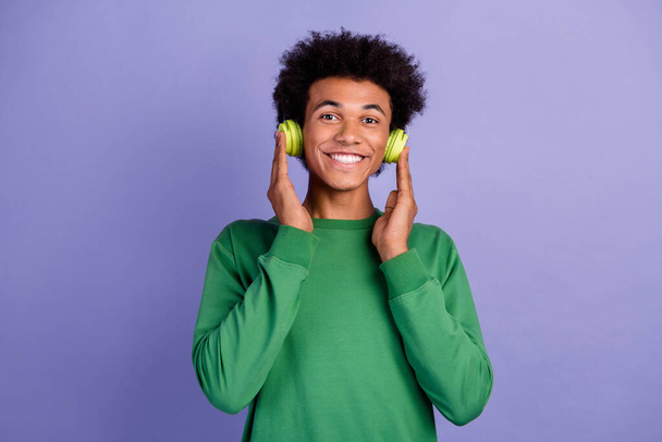 Photo of funny dreamy guy wear green pullover enjoying songs headphones isolated purple color background. - Photo, Image