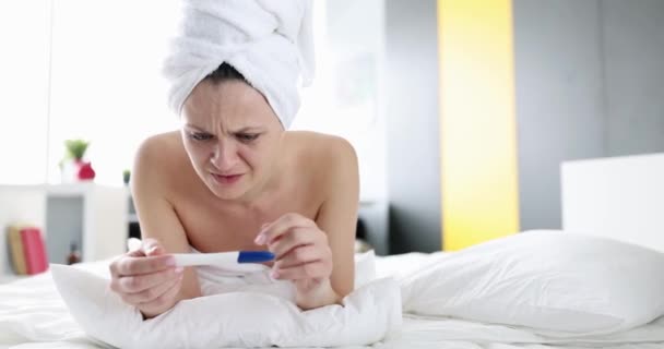 Молодая счастливая женщина с тест на беременность в спальне. Гинекология и долгожданная концепция беременности - Кадры, видео