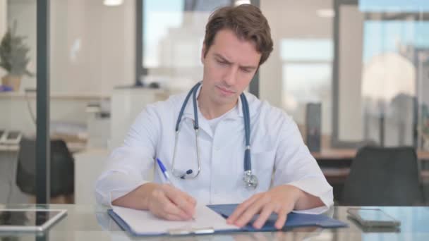 Médico varón trabajando en informe médico, documentación - Metraje, vídeo