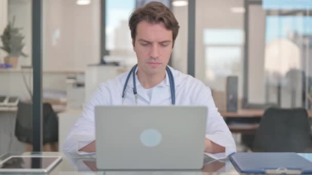 Αρσενικός γιατρός που εργάζεται στο φορητό υπολογιστή, δακτυλογράφηση - Πλάνα, βίντεο