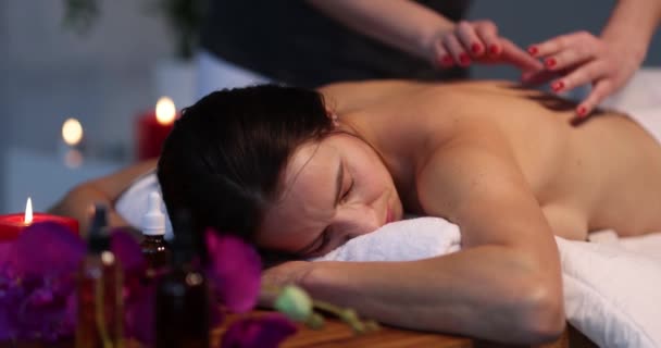 Relaxovaná žena dostává masáž zad ve wellness centru. Koncept masérských služeb - Záběry, video