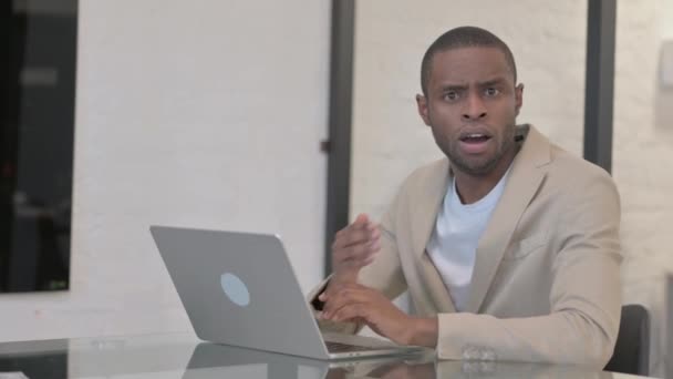 Shocked afro-americano uomo guardando fotocamera a lavoro - Filmati, video