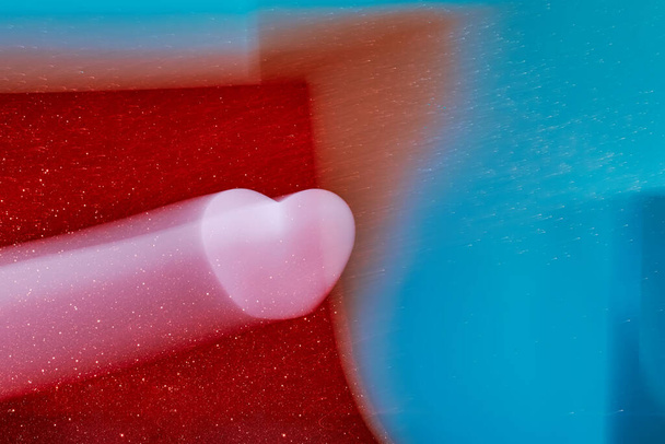 Abstrakti valokuvaus defocused vaaleanpunainen sydän lentää komeetta liikkeessä, joten pitkä näyttely punainen ja vaaleansininen kimalteleva tausta. - Valokuva, kuva