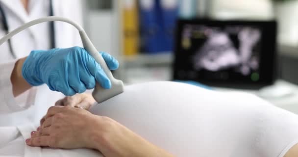 Pregnant woman undergoes ultrasound in clinic closeup. Ultrasound to determine sex of child concept - Footage, Video