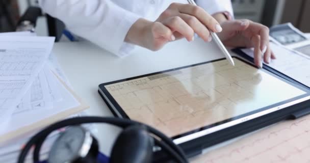 Medico tiene tablet con elettrocardiogramma in primo piano clinica. Diagnosi del concetto di aritmie cardiache e trattamento del cuore - Filmati, video